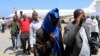 FILE- Deported Somali nationals gesture as they arrive at the airport in Somalia's capital of Mogadishu, April 9, 2014. Sixty-eight Somalis arrived in Magodishu Friday, having been deported by U.S. immigration authorities.