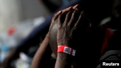 FILE: A migrant intercepted aboard a dinghy off the coast in the Mediterranean Sea, is seen with scabies on his body, after arriving on a rescue at the port of Malaga, southern Spain July 7, 2018.