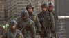 South Korean army soldiers patrol along a barbed-wire fence near the border village of Panmunjom in Paju, South Korea, March 27, 2013.