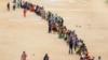 FILE - Hundreds of people line up to receive their second dose of vaccine against the coronavirus at the municipal ground, July 29, 2021, in Hyderabad, India. 