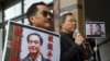 FILE - Pro-democracy Civic Party protesters carry portraits of missing booksellers Lee Bo, left, and Gui Minhai outside the Chinese Liaison Office in Hong Kong, Jan. 19, 2016.