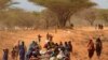Somalis fleeing hunger in their drought-stricken nation walk along the main road leading from the Somalian border to the refugee camps around Dadaab, Kenya