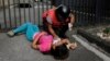An anti-government protester who was overcome by tear gas is aided by a paramedic during clashes after a rally demanding the resignation of President Nicolas Maduro, in Caracas, Venezuela, Jan. 23, 2019.