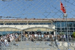 FILE - Turkish soldiers stand outside the court in a prison complex where the trial of prominent philanthropist Osman Kavala and 15 others started, while people arrive, in Silivri, outside Istanbul, June 24, 2019.