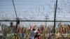 Visitors hang a ribbon on a wire fence decorated with other ribbons at the Imjingak Pavilion in Paju, South Korea, Tuesday, June 9, 2020. North Korea said Tuesday it will cut off all communication channels with South Korea as it escalates its…