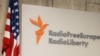 FILE - A sign for Radio Free Europe/Radio Liberty is seen next to a U.S. flag at the U.S.-funded broadcaster's headquarters in central Prague, Czech Republic, Oct. 5, 2005.