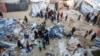 Palestinians inspect the damage at a tent camp sheltering displaced people, following an Israeli strike in Khan Younis on Dec. 18, 2024.