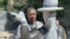 David Ngwerume working on his most talked about piece, which encourages people to mask up, in an exhibit called: “MJ" named after the late U.S. pop icon “Michael Jackson,” Harare, April 23, 2021. (VOA/Columbus Mavhunga)