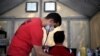 A Global Response Management worker checks the vital signs of a migrant patient at a camp where 2,000 people live while seeking asylum in the U.S., while the spread of coronavirus continues, in Matamoros, Mexico, April 9, 2020. 