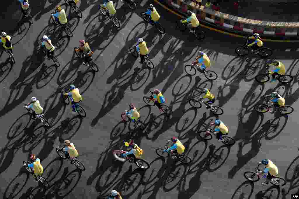 People ride bicycles during a mass cycle event to honor King Bhumibol Adulyadej in Narathiwat, southern Thailand. Crown prince Maha Vajiralongkorn led the symbolic 'Bike for Dad' event in Bangkok as people rode bicycles nationwide to celebrate the king's 88th birthday.