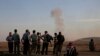 Turkish Kurds watch as airstrikes hit Kobani, inside Syria, as fighting intensifies between Syrian Kurds and the militants of Islamic State group, in Mursitpinar, on the outskirts of Suruc, at the Turkey-Syria border, Wednesday, Oct. 8, 2014.