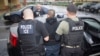 FILE - photo released by U.S. Immigration and Customs Enforcement shows foreign nationals being arrested this week during a targeted enforcement operation conducted by U.S. Immigration and Customs Enforcement (ICE).
