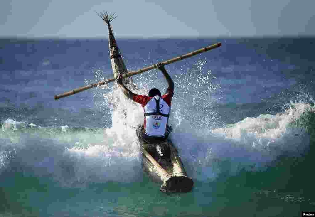 Peruvian surfer Carlos &#39;Huevito&#39; Areola rides a reed board, or &quot;caballito&quot; (little horse), into a wave at Sydney&#39;s Bondi Beach, Australia.