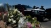 Flowers adorn a makeshift memorial near the scene of a mass shooting at a shopping complex in El Paso, Texas, Aug. 4, 2019.