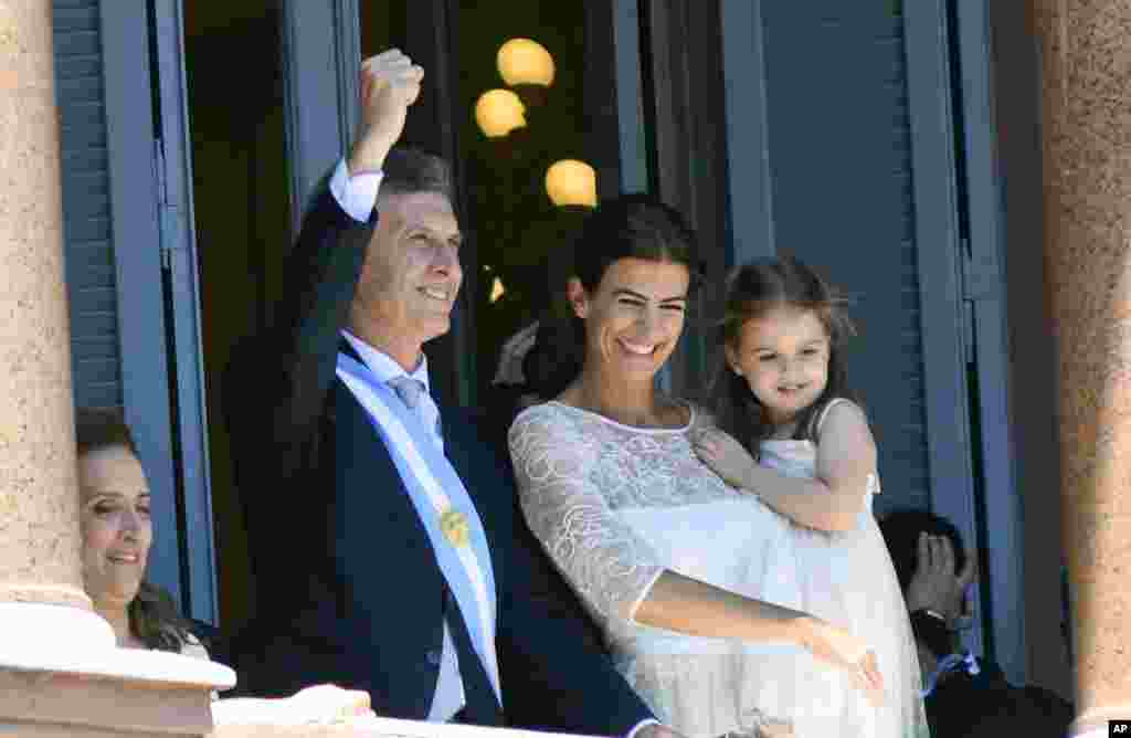 Accompanied by First Lady Juliana Awada and their daughter Antonia, Argentina&#39;s President Mauricio Macri greets the crowd from the balcony of the government house in Buenos Aires.