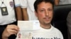 Italian Luigi Maraldi, left, whose stolen passport was used by a passenger boarding a missing Malaysian airliner, shows his passport at a Phuket police station in southern Thailand, March 9, 2014. 