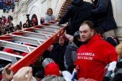 FILE - Pro-Trump protesters storm into the U.S. Capitol during clashes with police, to contest the certification of the 2020 U.S. presidential election results, Jan. 6, 2021.
