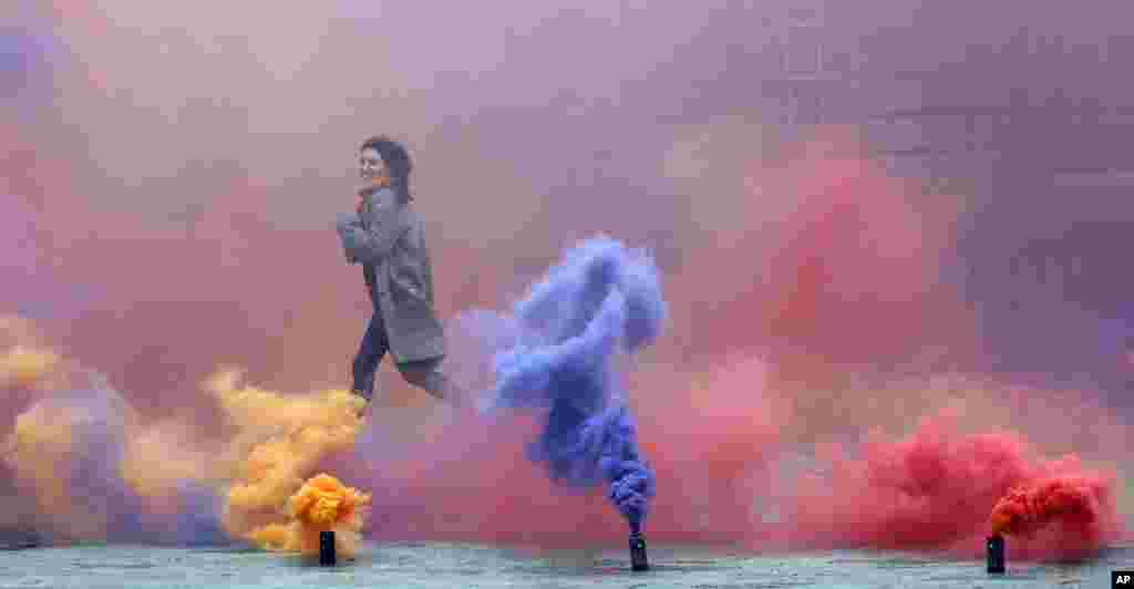 A woman runs through an artwork created by artist Filippo Minelli, a part of his series Silence/Shapes in Somerset House&rsquo;s courtyard, in London.