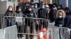 Customers, wearing masks, wait their turn to enter a bank in Los Angeles, Califiornia, April 3, 2020. 