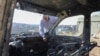 FILE - A Palestinian checks a car burned in an Israeli settlers raid near Salfit in the Israeli-occupied West Bank, Dec. 3, 2023. 