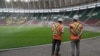 FILE - Workers from the Magil company standing near the pitch at the Olembe stadium in Yaounde, Cameroon, Aug. 8, 2021.