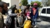 Members of Libyan internationally-recognized government forces evacuate an African family during the fighting with Eastern forces, at Al-Swani area in Tripoli, Libya, April 18, 2019. 