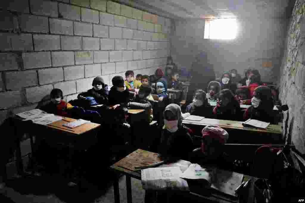 Syrian school children, wearing masks due to the COVID-19 pandemic, sit at a makeshift school set up by locals in the village of Ma&#39;arin on the outskirts of Azaz in the rebel-controlled northern countryside of Syria&#39;s Aleppo province.