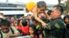 Philippine military personnel try to prioritize children and women first as people wait for evacuation flights in Tacloban, central Philippines, Nov. 12, 2013.