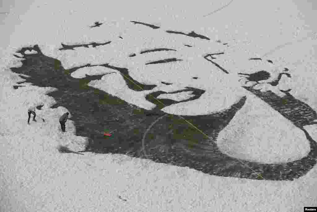 University students create an image of Marilyn Monroe by clearing snow off a soccer field, in Changchun, Jilin province, China.