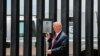 FILE - U.S. President Donald Trump prepares to autograph a plaque commemorating the construction of the 200th mile of border wall while visiting the wall on the U.S.-Mexico border in San Luis, Arizona, June 23, 2020.