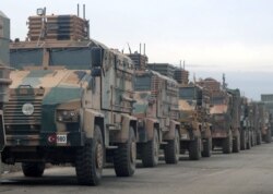FILE - Turkish military vehicles are seen in Hazano near Idlib, Syria, Feb. 11, 2020.