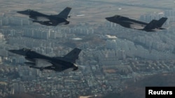 지난 2017년 12월 주한미군 군산기지에 배치된 F-16 전투기(왼쪽)와 미 유타주 힐 공군기지에서 전개한 F-35A 전투기가 군산 상공을 함께 비행하고 있다. (자료사진)