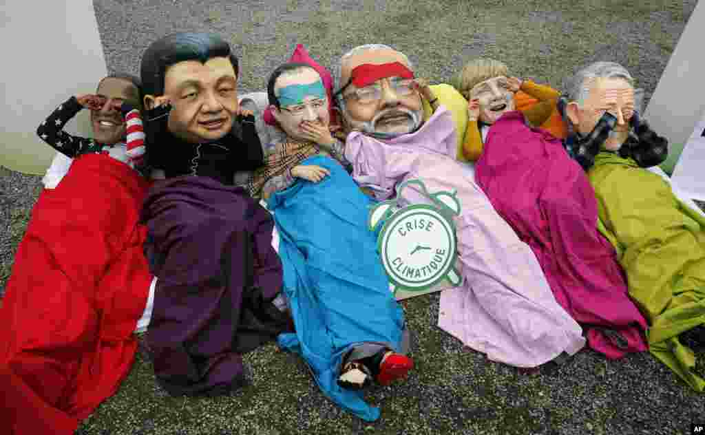 Oxfam activists wear masks of, from left, President Barack Obama, Chinese President Xi Jinping, French President Francois Hollande, India&#39;s Prime Minister Narendra Modi, German Chancellor Angela Merkel and Australia&#39;s Prime Minister Malcolm Turnbull as they stage a protest during the COP21, United Nations Climate Change Conference in Le Bourget, north of Paris, France.