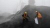 FILE - Employees from the local Entry-Exit Inspection and Quarantine Bureau collect samples of coal at a port in Rizhao, Shandong province.