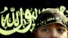 Arhiva - Dečak stoji ispred zastave Islamskog džijada. Mnoge zapadne zemlje zaziru od toga da Islamska država, nakon gubitka teritorija, aktivno nastavlja da regrutuje pristalice i po evropskim zemljama, uključujući i decu.