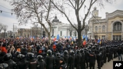 Službenici interventne policije stoje u redu ispred demonstranata tokom protesta koji su pokrenuli Pokret za narod i članovi Moldavske stranke Šor naklonjene Rusiji, protiv prozapadne vlade i niskog životnog standarda, u Kišinjevu, Moldavija, u utorak, februar. 28, 2023