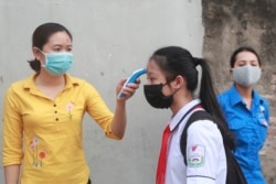 A student is scanned for temperature before entering Dinh Cong secondary school in Hanoi, Vietnam, May 4, 2020.