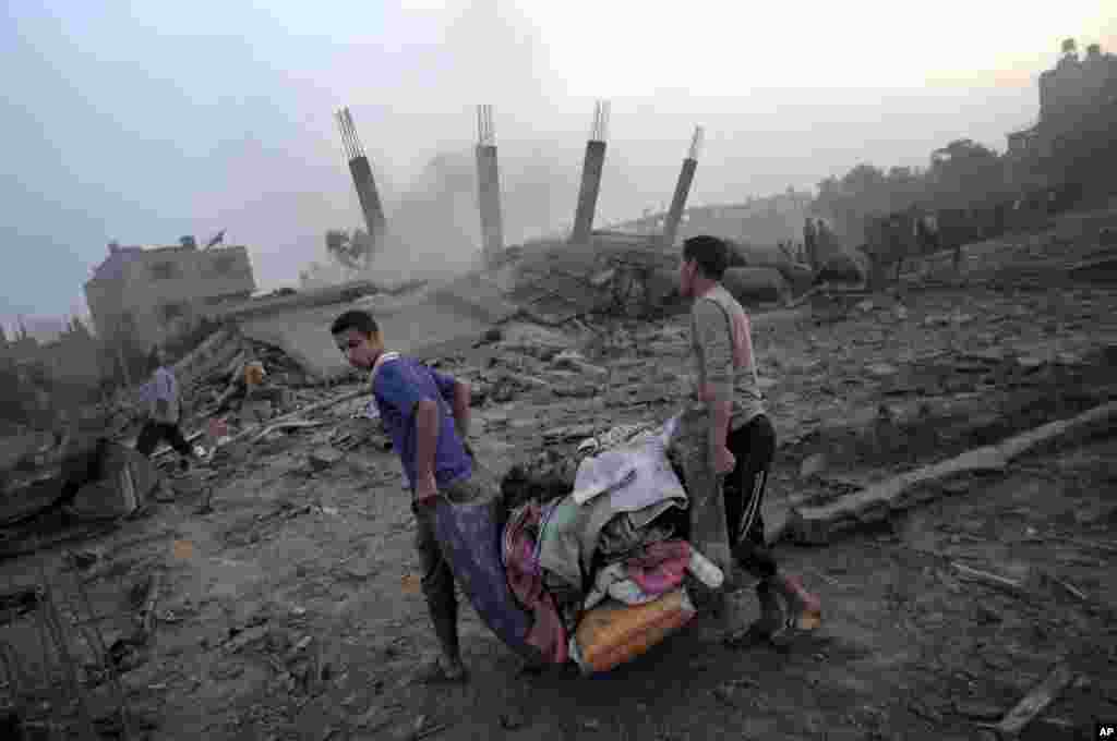 Warga Palestina mencoba menyelamatkan apa yang tersisa dari puing-puing rumah yang dihancurkan oleh serangan udara Israel di kota Gaza (8/7).&nbsp;(AP/Khalil Hamra)