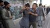 A shocked man shouts slogans against President Ghani after he ran out of the Shiite mosque during an ongoing attack, Kabul, Afghanistan, Aug. 25, 2017. 