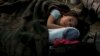 A child from Ukraine sleeps in a tent part of a humanitarian centre for refugees at the Moldovan-Ukrainian border, in Palalanca, Moldova, Feb. 25, 2022. 