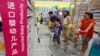 FILE - A family looks at foreign imported milk powder products at a supermarket in Beijing, July 3, 2013.