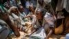 FILE - An Ethiopian woman argues with others over the allocation of yellow split peas distributed by the Relief Society of Tigray in the town of Agula, in the Tigray region of northern Ethiopia, on May 8, 2021.