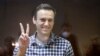 Le chef de l'opposition russe Alexei Navalny fait des gestes pendant son procès au tribunal de district de Babuskinsky à Moscou, en Russie, samedi 20 février 2021.