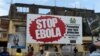 FILES - People walking past a billboard reading "Stop Ebola" in Freetown, Sierra Leone, Nov. 7, 2014. 