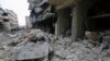FILE - People inspect a damaged site after airstrikes on the town of Ariha, in Idlib Province, Syria, Jan. 30, 2020.