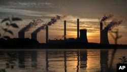 FILE - The coal-fired Plant Scherer, one of the nation's top carbon dioxide emitters, stands in the distance in Juliette, Georgia, June, 3, 2017.