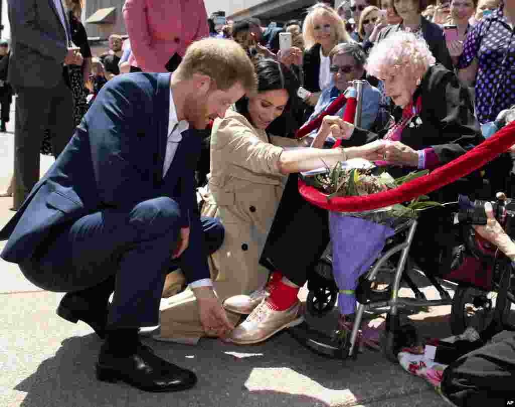 Britain&#39;s Prince Harry and Meghan, Duchess of Sussex, meet 98-year-old Daphne Dunne during a walkabout outside the Opera House in Sydney, Australia. Prince Harry and his wife Meghan are on a 16-day tour of Australia and the South Pacific.