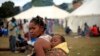 A woman makes her way through a refugee camp, April 15, 2015, where more than 2,000 foreigners have sought shelter in Durban, South Africa after deadly attacks on immigrants. 