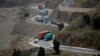 Trucks carry goods on the way to neighboring Afghanistan through the Khyber Pass in Pakistani tribal area, March 21, 2017. A Pakistani border official says hundreds of trucks have crossed into Afghanistan from Pakistan after the border reopened for the fi