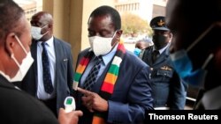 Zimbabwe's President Mnangagwa has his temperature taken as he arrives at the parliament in Harare, April 20, 2021.